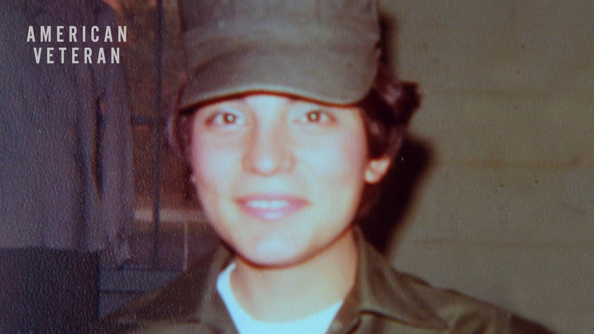 Photo of a young, female veteran of color with the "American Veteran" logo on the top left corner